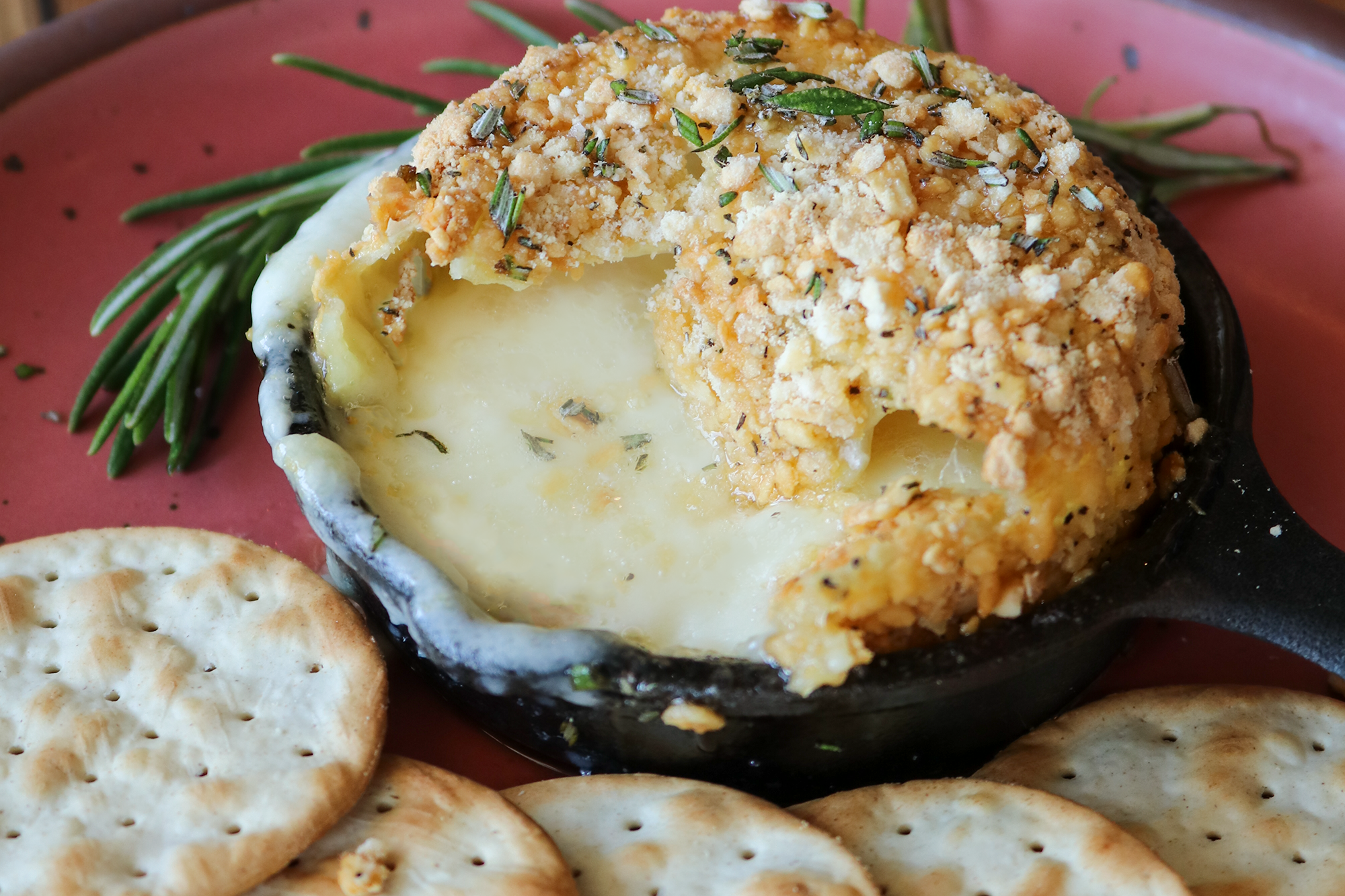 Baked Brie with Hot Honey on a plate with crackers