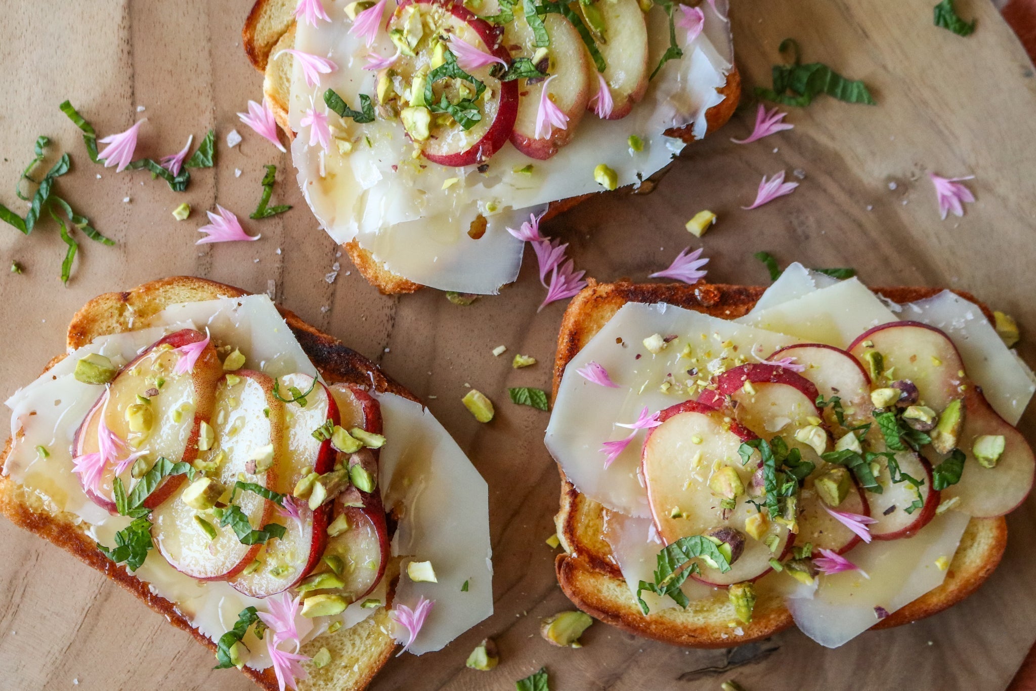 Toma & Peach toasts with pistachios and honey on board