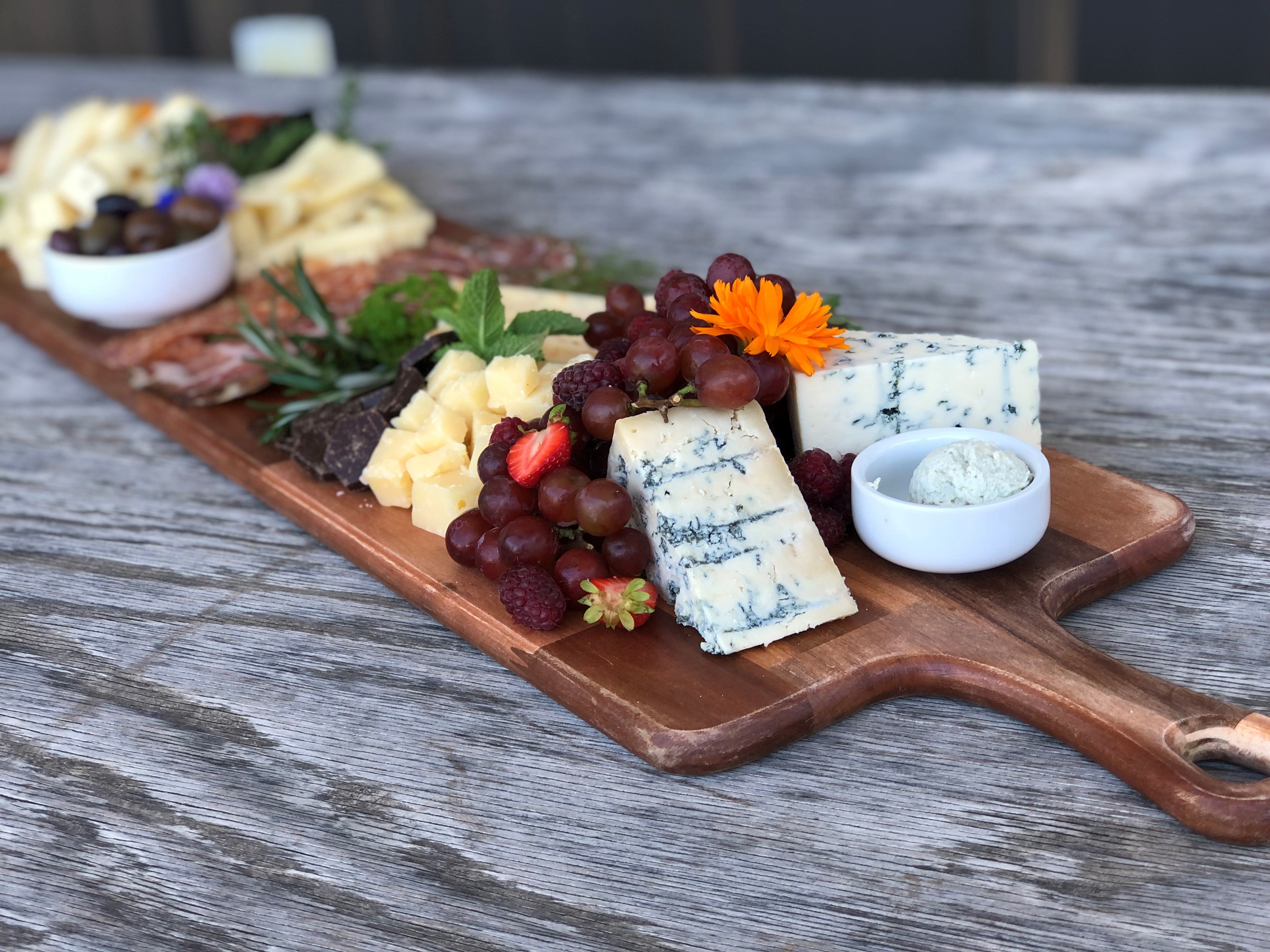 a cheeseboard with edible flowers and fresh herbs