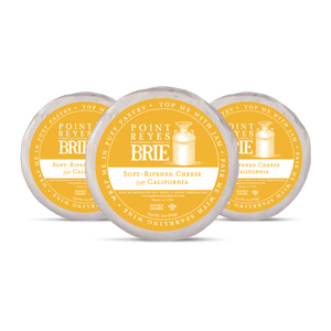 Three containers of Point Reyes Brie cheese on a white background