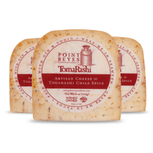 Three blocks of Point Reyes Togarashi Artisan Cheese on a white background