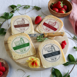 packaged toma with attitude cheese pack on a round board