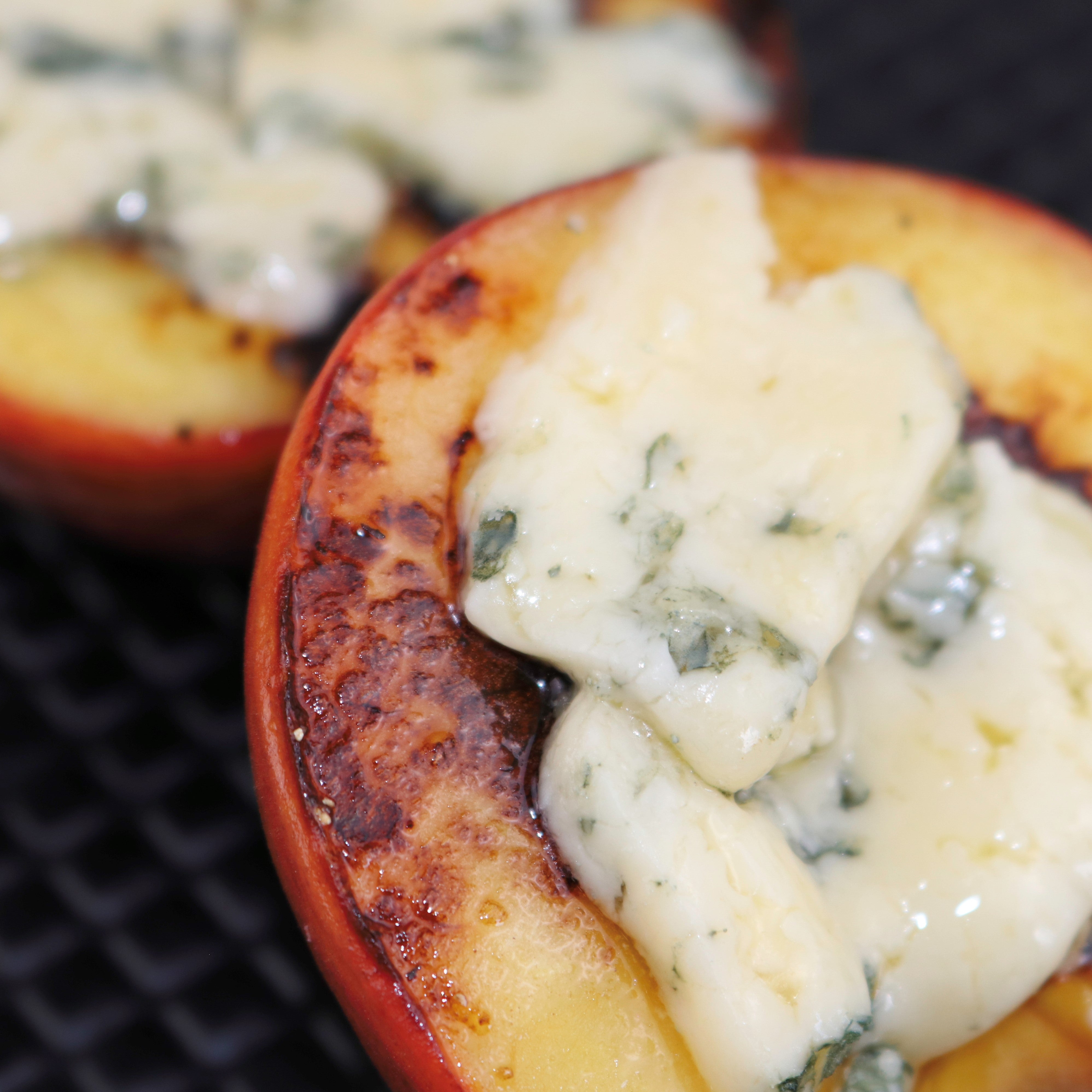Grilled peaches with melted Bay Blue cheese on top
