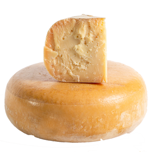 A wheel and wedge of Aged Gouda on a white background